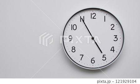 Minimalist Analog Wall Clock with White Face and Simple Black Hands Showing 16.55/04.55 - Ideal for Time Management and Modern Decor Concepts Minimalist Analog Wall Clock with White Face and Simple Black Hands Showing 16.55/04.55 - Ideal for Time Management and Modern Decor Concepts 121929104