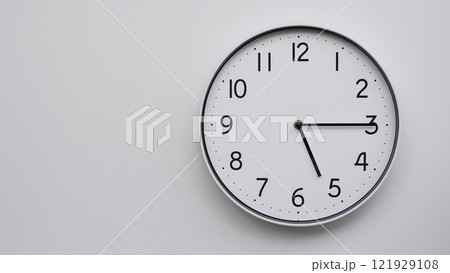 Minimalist Analog Wall Clock with White Face and Simple Black Hands Showing 17.15/05.15 - Ideal for Time Management and Modern Decor Concepts 121929108