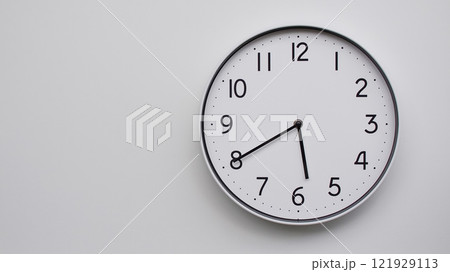 Minimalist Analog Wall Clock with White Face and Simple Black Hands Showing 17.40/05.40 - Ideal for Time Management and Modern Decor Concepts 121929113