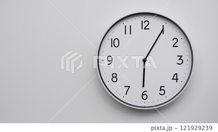 Minimalist Analog Wall Clock with White Face and Simple Black Hands Showing 18.05/06.05 - Ideal for Time Management and Modern Decor Concepts 121929239