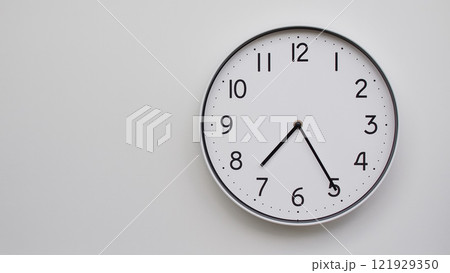 Minimalist Analog Wall Clock with White Face and Simple Black Hands Showing 19.25/07.25 - Ideal for Time Management and Modern Decor Concepts 121929350