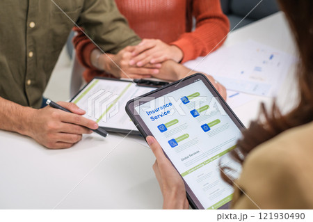 Asian financial consultant explaining investment insurance to couple using a laptop at home.financial planning for future goals. Asian financial consultant explaining investment insurance to couple using a laptop at home.financial planning for future goals. 121930490