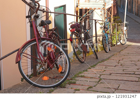 Bicycles on old street in Liguria. City buildings on sunny day. Sport and transport. Travelling, sightseeing and holidays in Italy 121931247