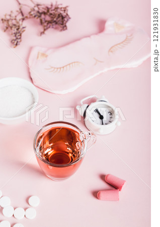 Cherry juice with magnesium powder against insomnia, earplugs and alarm clock vertical  view 121931830