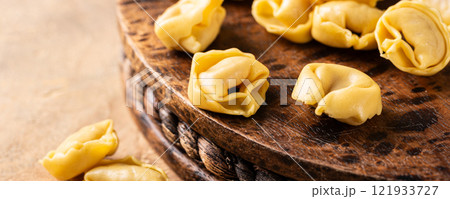 Fresh Tortellini Cappelletti Pasta on Wooden Board 121933727