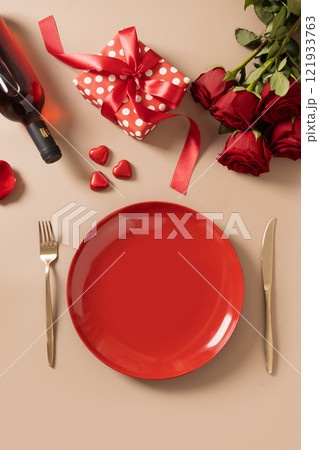 Valentine's day dinner with red plate, romantic gift and red roses. Valentine's day dinner with red plate, romantic gift and red roses. 121933763
