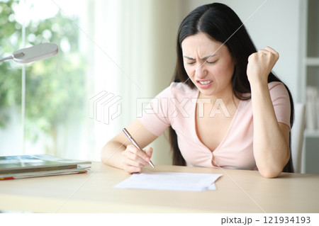 Angry asian woman reading contract before sign it 121934193