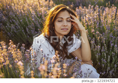 Young white woman lies among lavender bushes 121934721