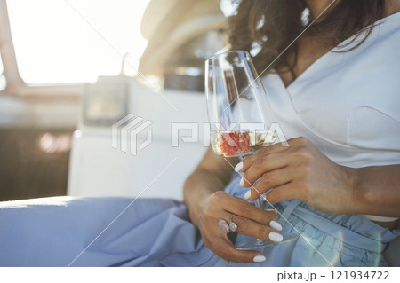 Female hand holding glasses of champagne with raspberries on board the boat 121934722