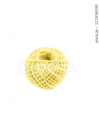 A roll of yellow jute twine placed on a white background, ideal for crafting, packaging, and DIY projects. Perfect for online stores or product catalogs showcasing eco-friendly materials 121936090