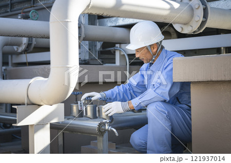 ビルの設備点検をするベテランの作業員 121937014
