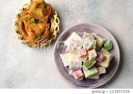 Sweets served on elegant plates display traditional desserts at a festive gathering Sweets served on elegant plates display traditional desserts at a festive gathering 121937256