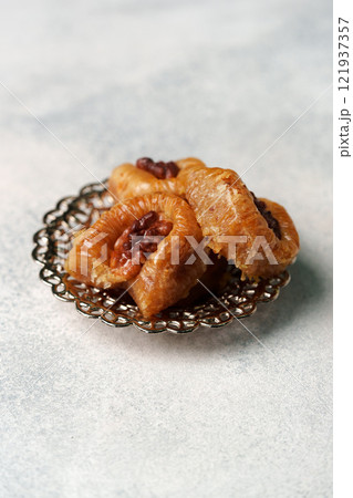 Delicious sweet pastries displayed on a decorative plate in a soft natural light setting Delicious sweet pastries displayed on a decorative plate in a soft natural light setting 121937357
