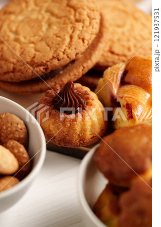 Freshly baked sweets and pastries arranged on a white background showcasing various textures and flavors Freshly baked sweets and pastries arranged on a white background showcasing various textures and flavors 121937531