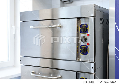 Modern stainless steel oven in a bright, contemporary kitchen with dual cooking compartments 121937562