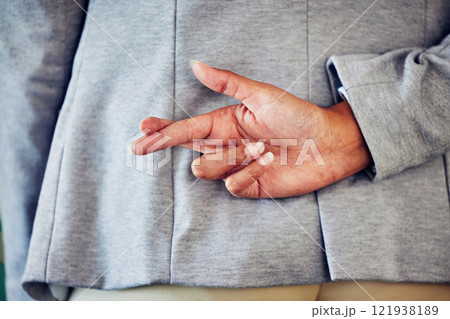 Hand gesture, sign or icon of a liar not telling the truth and being dishonest. Female waiting for good news and holding a sign. Woman crossing fingers for good luck, hope or a lie, behind her back. 121938189