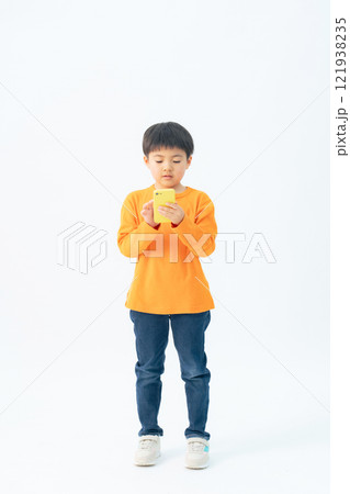 スマホを見る男の子の全身写真 スマホを見る男の子の全身写真 121938235