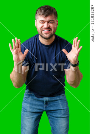 A surprised man expresses shock against a bright green background 121938297