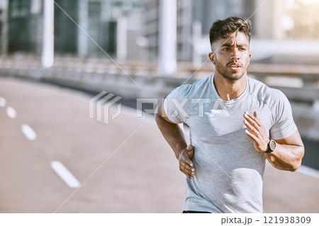 Runner running for fitness training on the street in urban city, doing cardio exercise and sport on the street. Serious, fit and sporty man jogging for health, exercising and doing routine run 121938309