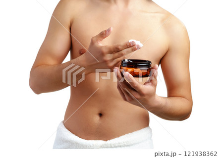 A young man applying skincare cream on his face with a focused expression, demonstrating personal grooming at home A young man applying skincare cream on his face with a focused expression, demonstrating personal grooming at home 121938362