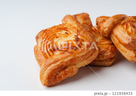 Freshly baked pastries arranged on a clean surface showcasing their golden-brown layers and swirl patterns 121938433