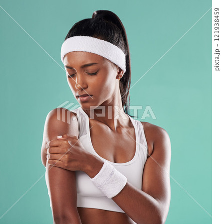 Tennis player with sports injury, hurt or pain in her arm after practice against green studio background. Professional female athlete suffering muscle strain, accident and inflammation on her body Tennis player with sports injury, hurt or pain in her arm after practice against green studio background. Professional female athlete suffering muscle strain, accident and inflammation on her body 121938459
