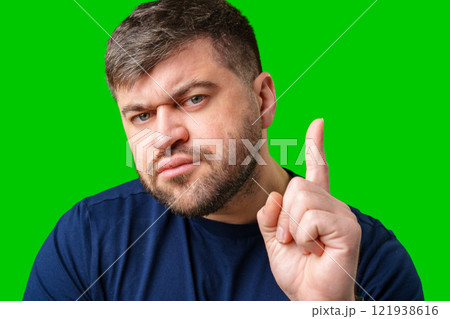 A man thoughtfully ponders on a bright green background A man thoughtfully ponders on a bright green background 121938616