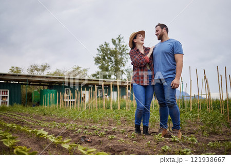 Farmer couple happy about growing vegetable crops or plants in their organic or sustainable farm or garden. Affectionate nature activists enjoying the outdoors and having fun together Farmer couple happy about growing vegetable crops or plants in their organic or sustainable farm or garden. Affectionate nature activists enjoying the outdoors and having fun together 121938667