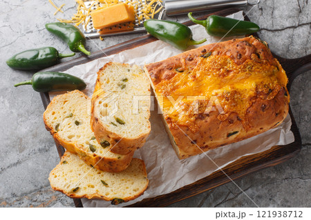 Jalapeno Cheddar Bread is perfectly crusty on the outside, with a soft fluffy inside closeup on the wooden board. Horizontal top view Jalapeno Cheddar Bread is perfectly crusty on the outside, with a soft fluffy inside closeup on the wooden board. Horizontal top view 121938712