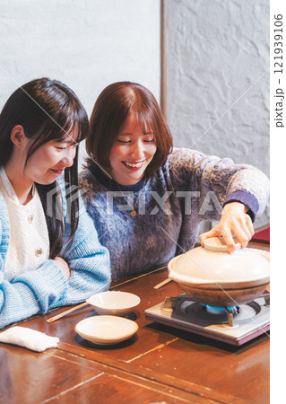 カニ鍋で女子会をする若い女性【撮影協力・海鮮居酒屋　魚魯こ】 121939106