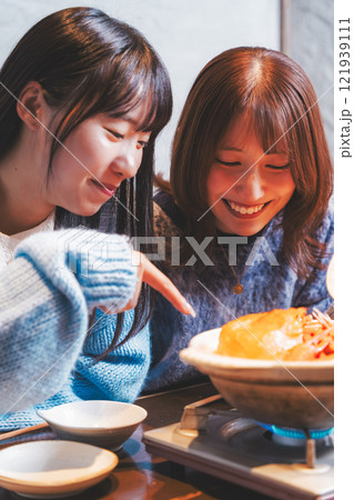 カニ鍋で女子会をする若い女性【撮影協力・海鮮居酒屋 魚魯こ】 カニ鍋で女子会をする若い女性【撮影協力・海鮮居酒屋 魚魯こ】 121939111