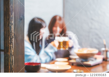 カニ鍋を前に乾杯をする若い女性二人【撮影協力・海鮮居酒屋　魚魯こ】 121939163