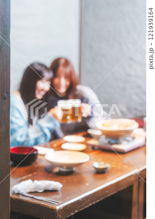 カニ鍋を前に乾杯をする若い女性二人【撮影協力・海鮮居酒屋 魚魯こ】 カニ鍋を前に乾杯をする若い女性二人【撮影協力・海鮮居酒屋 魚魯こ】 121939164