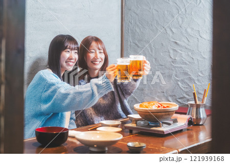 カニ鍋を前に乾杯をする若い女性二人【撮影協力・海鮮居酒屋　魚魯こ】 121939168