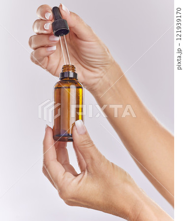 Skincare serum, essential oil and cosmetic product in woman hand for perfect, smooth skin or reduce wrinkles isolated on studio background. Closeup hands using body care or anti aging liquid drop Skincare serum, essential oil and cosmetic product in woman hand for perfect, smooth skin or reduce wrinkles isolated on studio background. Closeup hands using body care or anti aging liquid drop 121939170