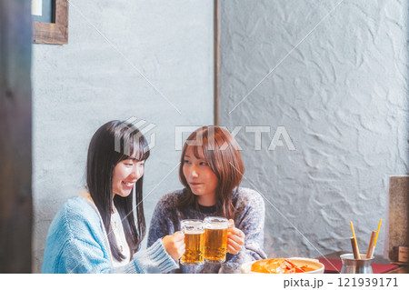 カニ鍋を前に乾杯をする若い女性二人【撮影協力・海鮮居酒屋　魚魯こ】 121939171