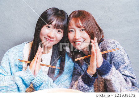 カニ鍋を前にいただきますをする若い女性二人【撮影協力・海鮮居酒屋　魚魯こ】 121939172