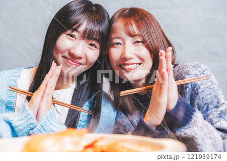 カニ鍋を前にいただきますをする若い女性二人【撮影協力・海鮮居酒屋 魚魯こ】 カニ鍋を前にいただきますをする若い女性二人【撮影協力・海鮮居酒屋 魚魯こ】 121939174