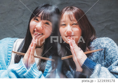カニ鍋を前にいただきますをする若い女性二人【撮影協力・海鮮居酒屋　魚魯こ】 121939178