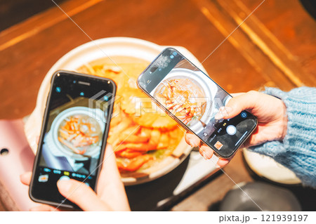 映えるカニ鍋をスマホで撮る若い女性二人【撮影協力・海鮮居酒屋　魚魯こ】 121939197
