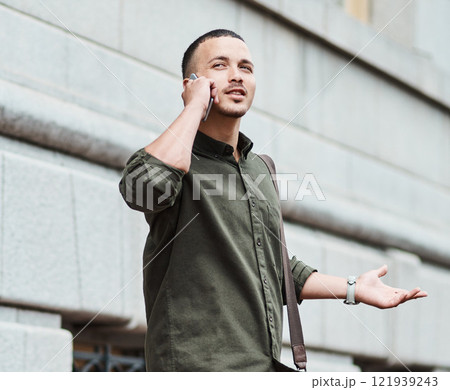 Lost man, traveler or tourist talking on a phone call asking for directions in a new city. A confused young male on vacation in an urban town looking around to find his hotel or the airport 121939243