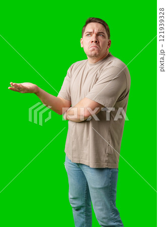 A man stands with arms crossed and a thoughtful expression in front of a green screen A man stands with arms crossed and a thoughtful expression in front of a green screen 121939328
