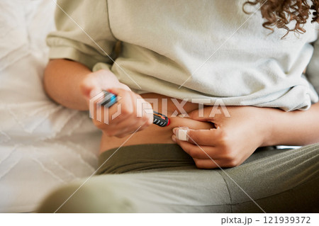 Diabetes, diabetic woman with a chronic disease injecting herself with insulin treatment at home. Closeup of a female taking glucose medication or medicine to control blood sugar levels 121939372