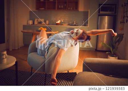 Face, skin and self care woman relaxing at home with facial mask and calming candle lights for a relaxed therapeutic atmosphere on a Friday night. Girl with a routine skincare treatment on the sofa 121939383