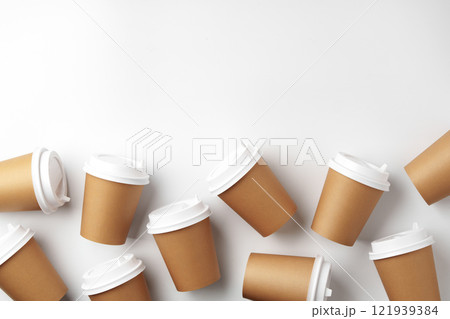 A variety of disposable coffee cups arranged artistically on a clean white surface A variety of disposable coffee cups arranged artistically on a clean white surface 121939384