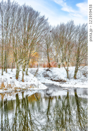 Remarkable landscape in city park with snowy trees and beautiful frozen river 121939438