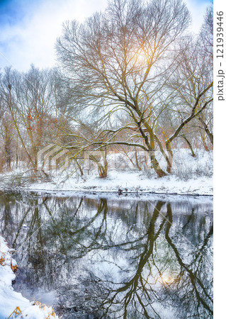 Remarkable landscape in city park with snowy trees and beautiful frozen river Remarkable landscape in city park with snowy trees and beautiful frozen river 121939446