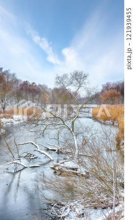 Outstanding landscape in city park with snowy trees and beautiful frozen river. Outstanding landscape in city park with snowy trees and beautiful frozen river. 121939455