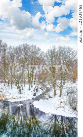 Remarkable landscape in city park with snowy trees and beautiful frozen river Remarkable landscape in city park with snowy trees and beautiful frozen river 121939468