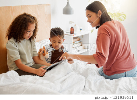 Mother and children browsing a digital tablet in the bed at home, bonding and learning to use technology. Family on the internet online to play games and learn from educational apps or website 121939511